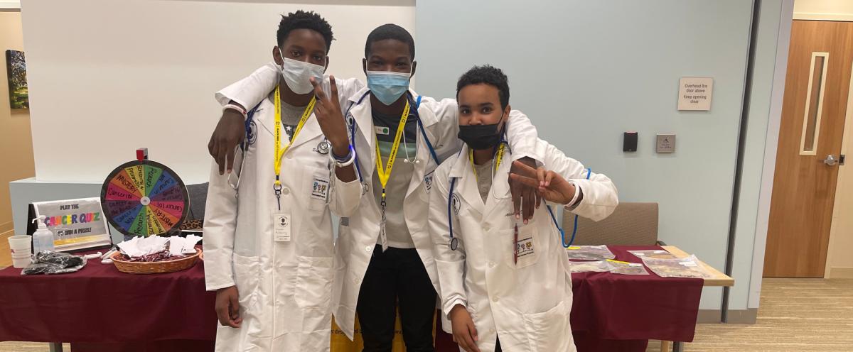3 young men wearing lab coats 