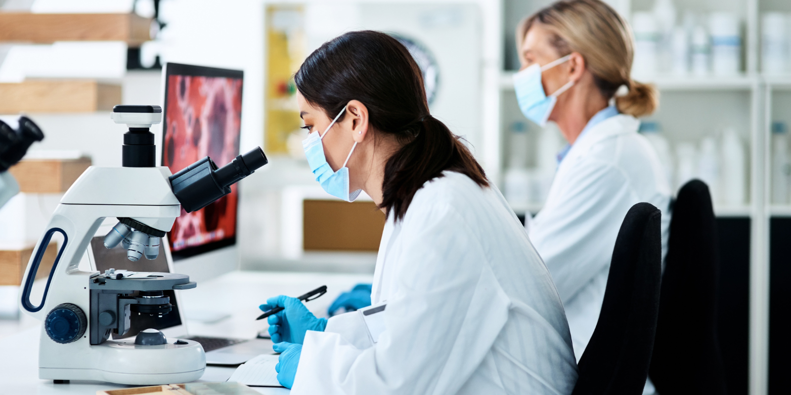 Person looking through microscope at sample