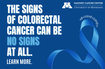 White bold text sits on top of a checker-patterned royal blue background. The text reads "The signs of colorectal cancer can be no signs at all. Learn more." To the right of the text, there is a large blue ribbon signifying colorectal cancer awareness.
